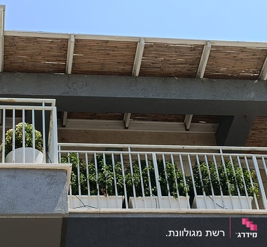 מרפסת עם עציצים וגדר מתכת לבנה